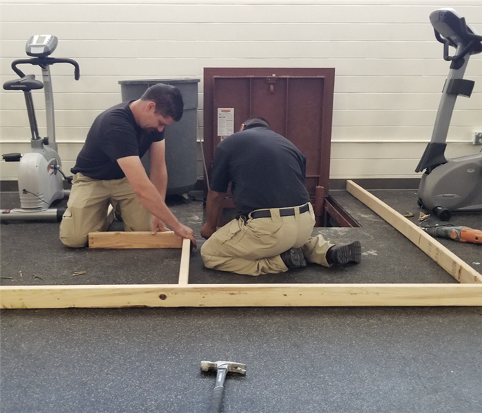 Removing damaged flooring from gym