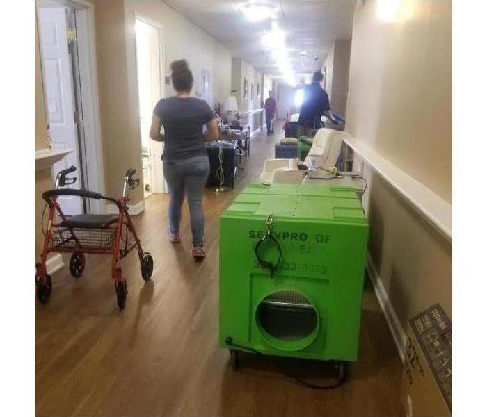 Drying equipment in a hallway, people on the hallway